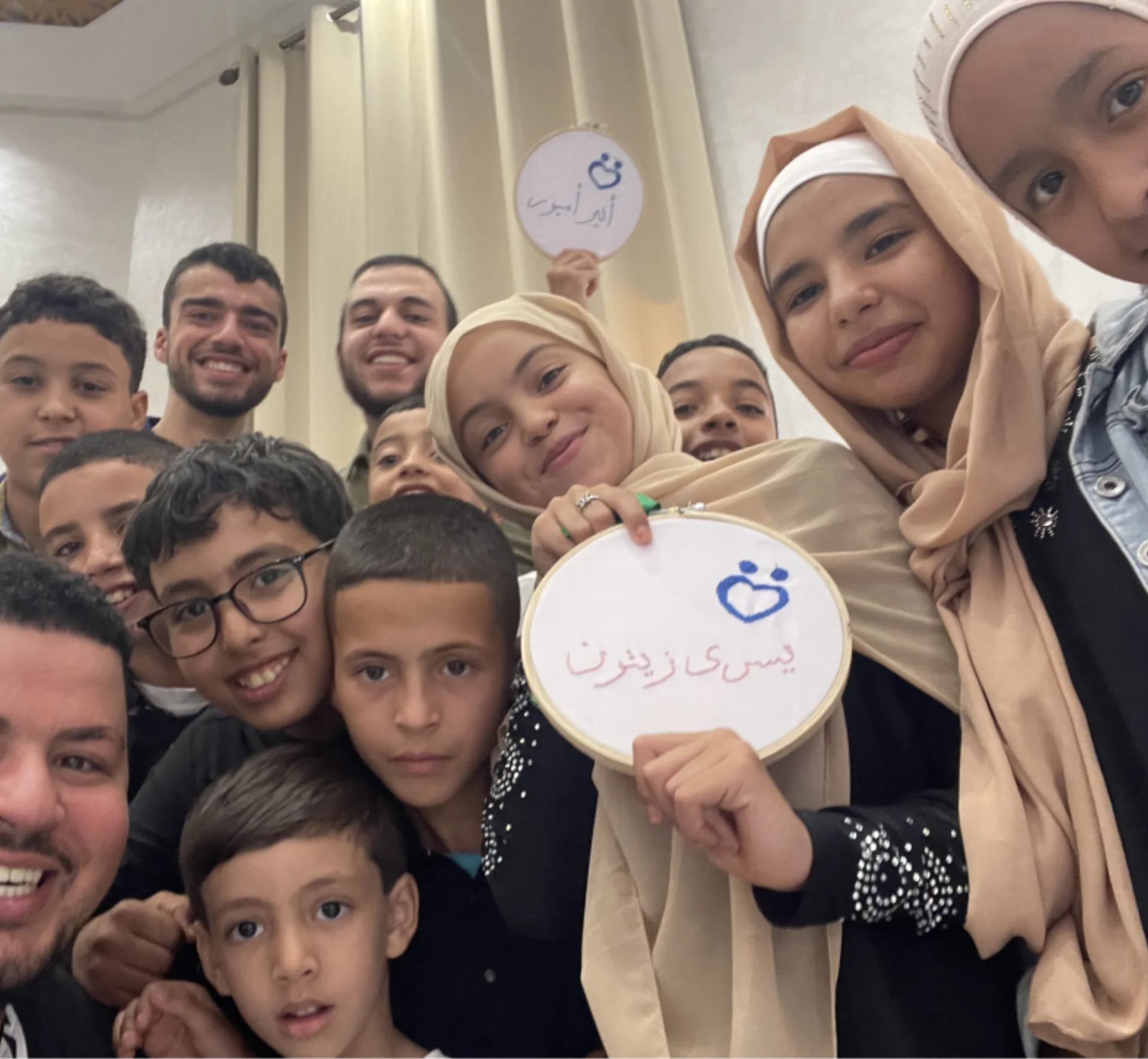 Group selfie with embroidered sign
